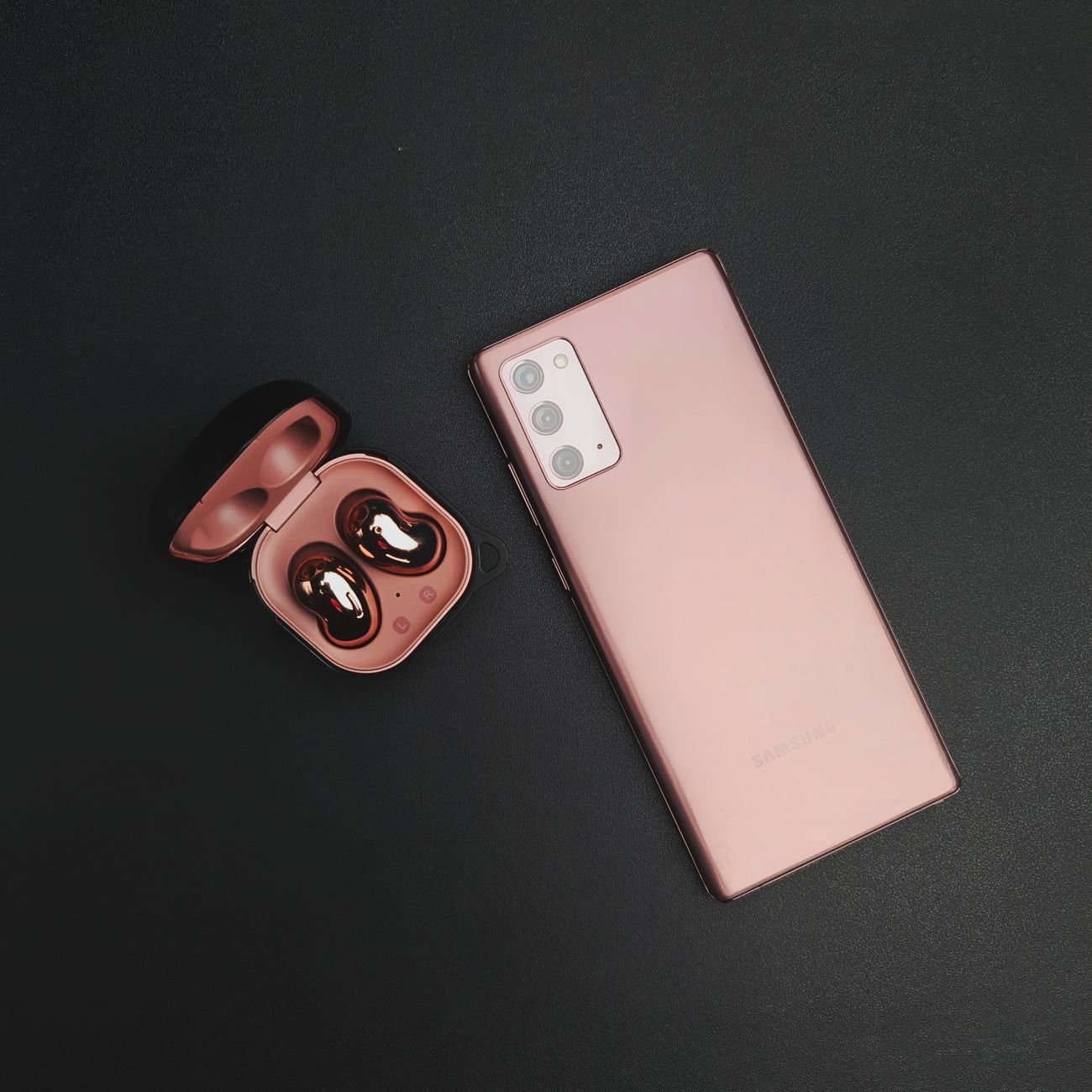 Modern smartphone paired with wireless earbuds on a minimalist black background